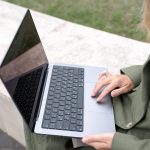 Osoba trzyma laptop z literami l na nim
