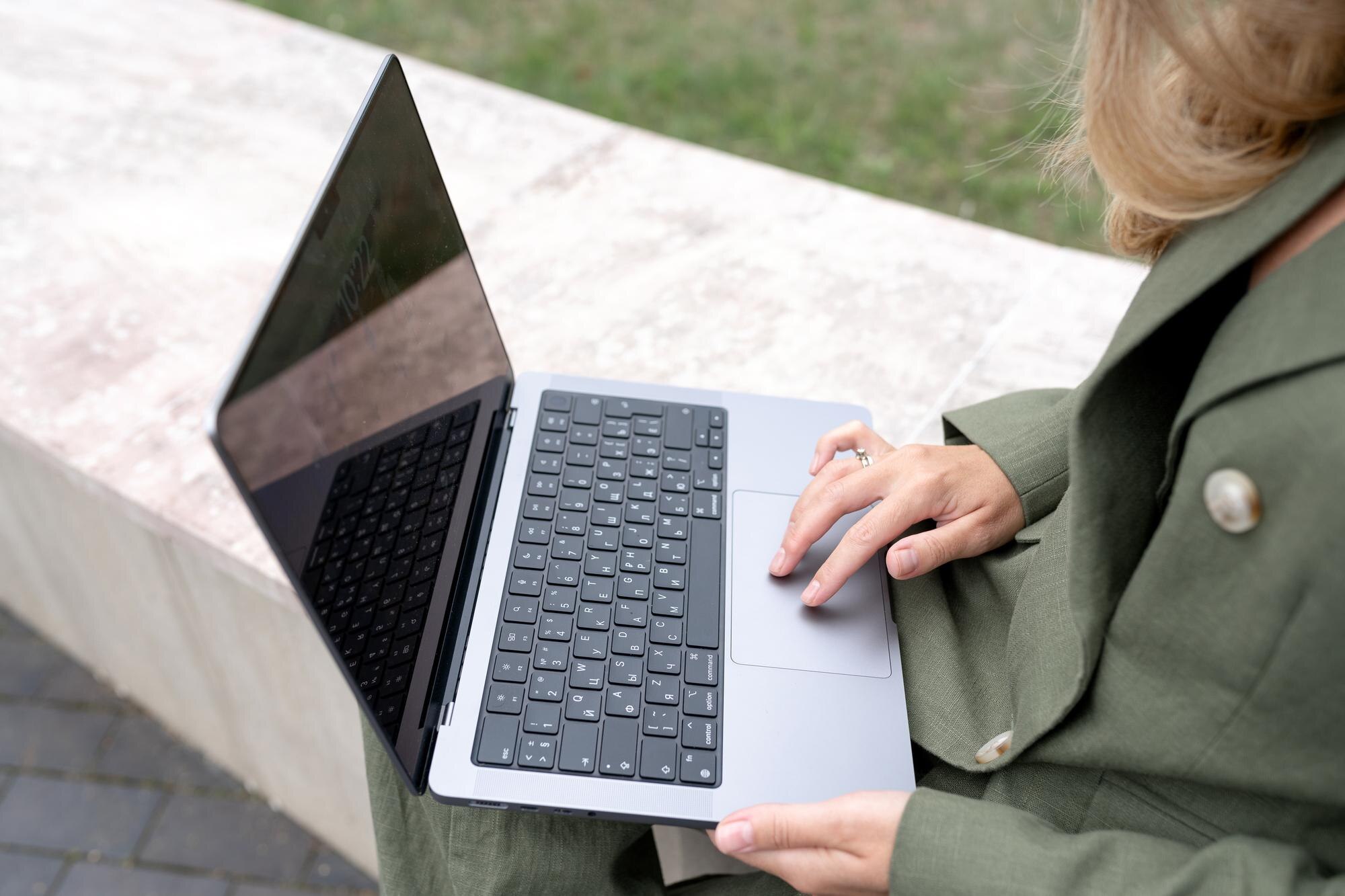 Osoba trzyma laptop z literami l na nim