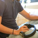 Mężczyzna czyta książkę siedząc na kanapie w domu