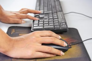 osoba używająca myszy komputerowej z literami q na klawiaturze