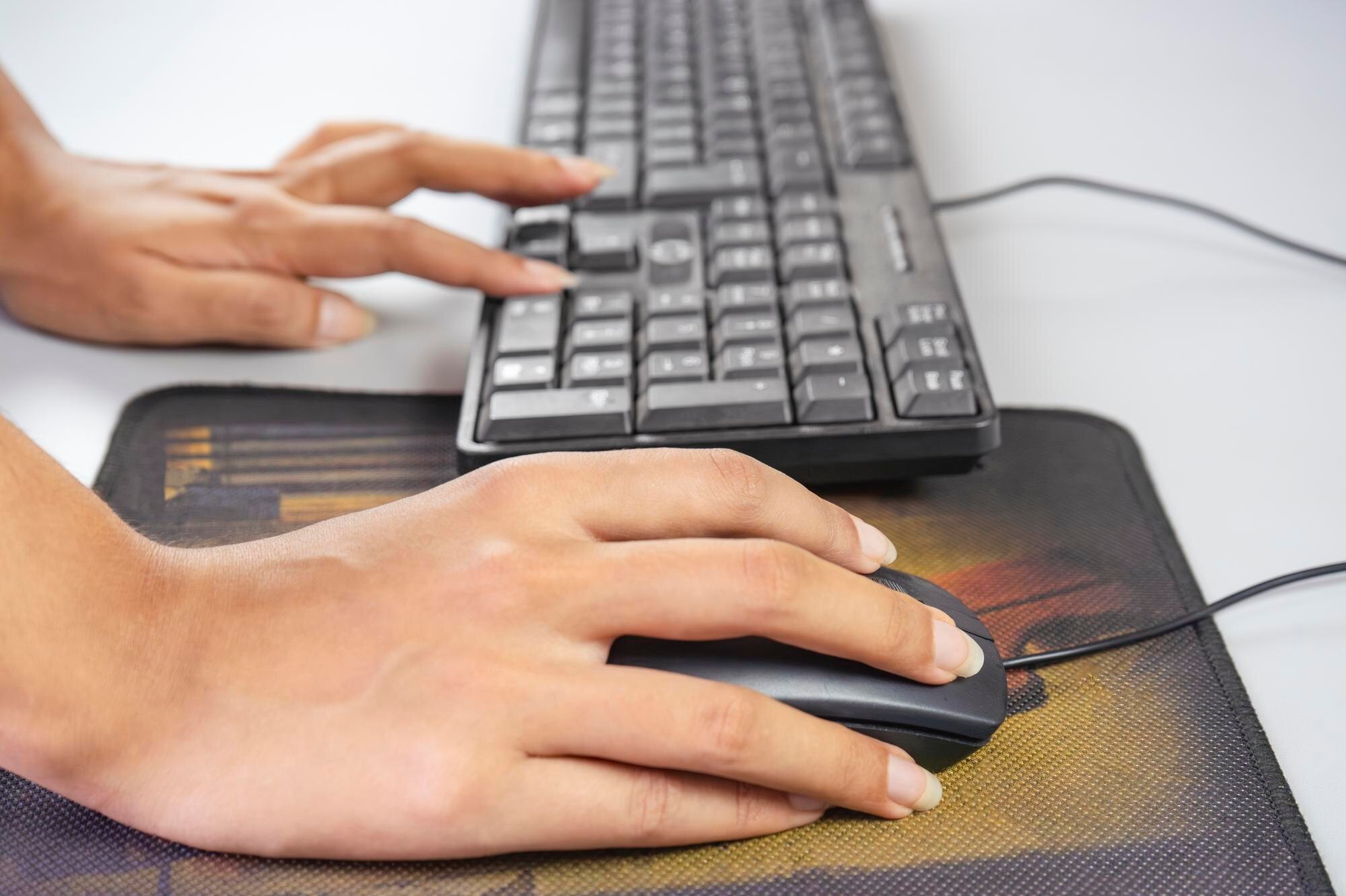 osoba używająca myszy komputerowej z literami q na klawiaturze