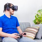 Mężczyzna grający w wirtualną rzeczywistość z goglami VR