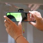 Zbliżenie dłoni kobiety próbującej wyregulować lusterko samochodowe