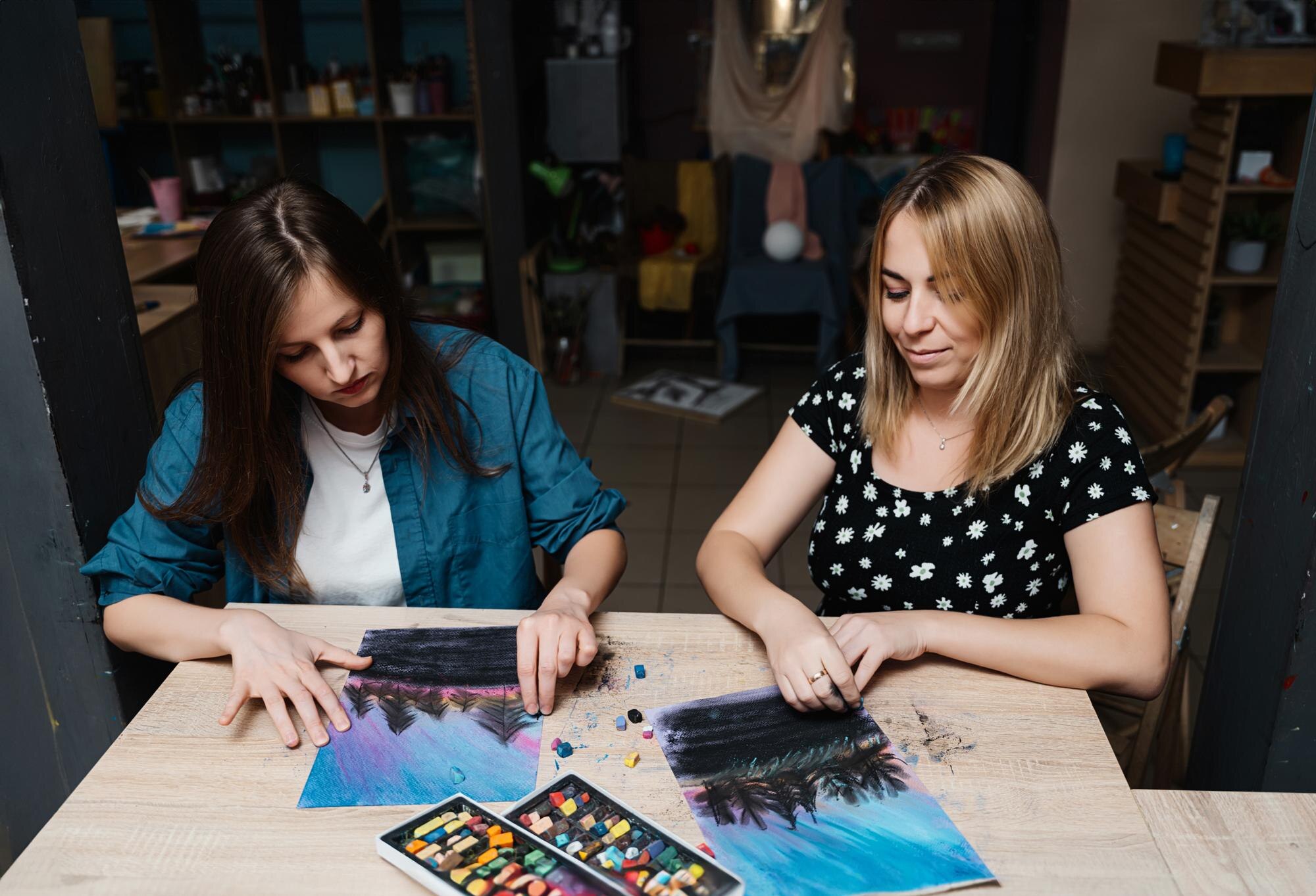 Dwie kobiety zajmujące się sztuką, używające pastelów do tworzenia pięknych krajobrazów