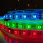 Zestaw kolorowych goniących pasków LED z jasnymi neonowymi czerwonymi zielonymi i niebieskimi światłami umieszczonymi na stole, RGB