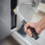 Kobieta trening na ciągnąć w dół triceps maszynę w sprawności fizycznej gym.