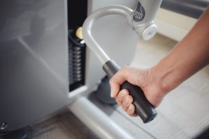 Kobieta trening na ciągnąć w dół triceps maszynę w sprawności fizycznej gym.