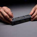 Osoba demonstrująca precyzję za pomocą narzędzi naprawiających skomplikowane elementy elektroniczne