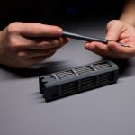 Osoba demonstrująca precyzję za pomocą narzędzi naprawiających skomplikowane elementy elektroniczne