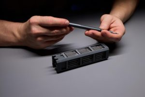 Osoba demonstrująca precyzję za pomocą narzędzi naprawiających skomplikowane elementy elektroniczne