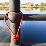 Czerwony zamek stodoły w kształcie serca wisi na poręczy mostu Tradycja ślubna do powieszenia