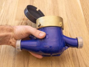 Nowy nieużywany wodomierz w ręce mężczyzny