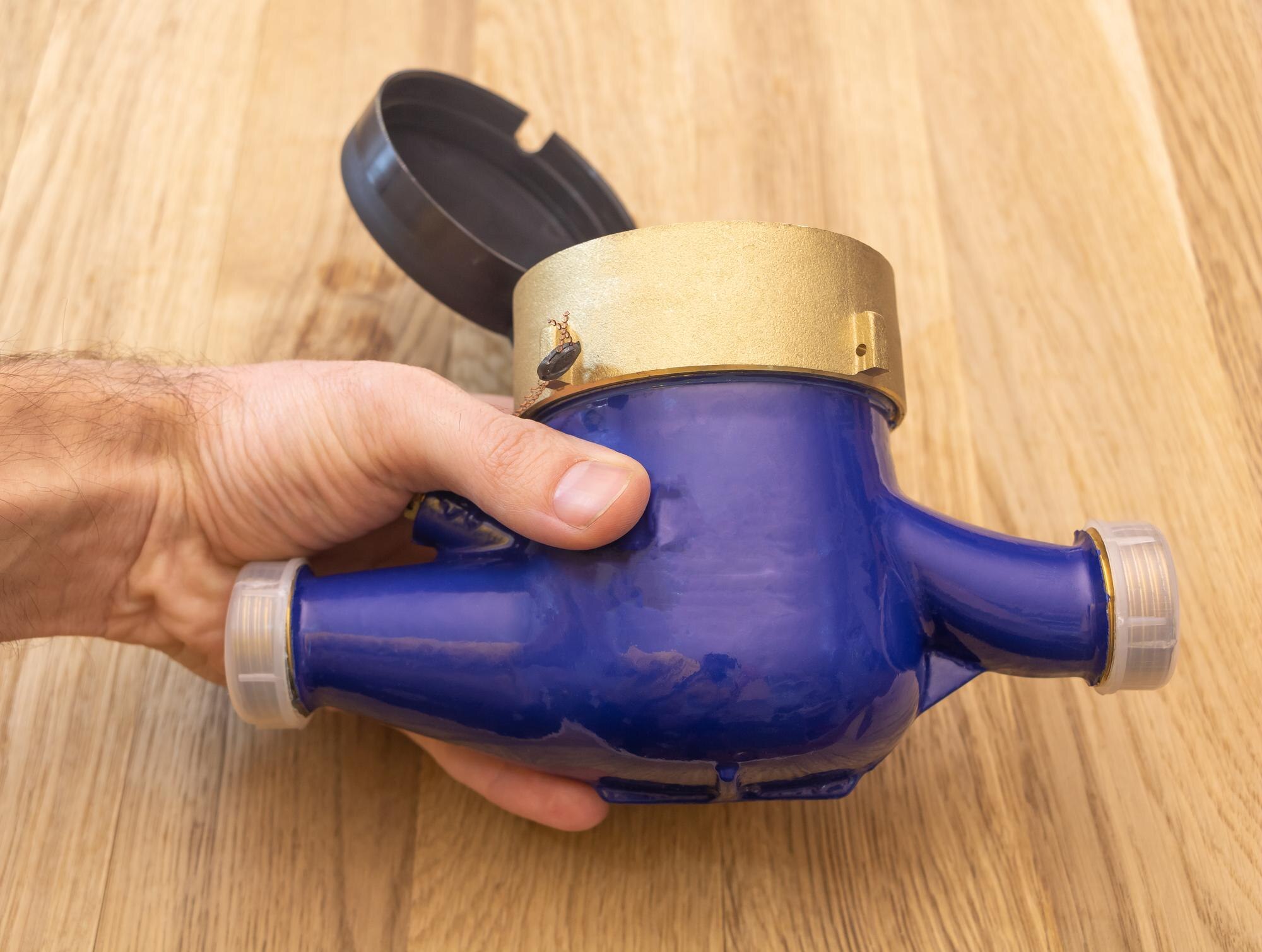 Nowy nieużywany wodomierz w ręce mężczyzny