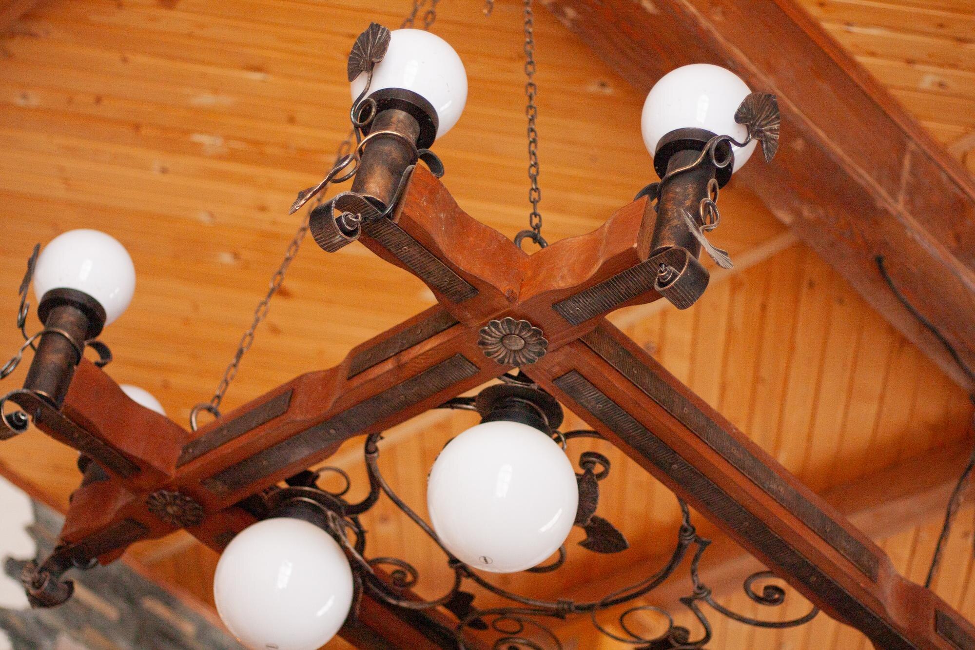 starożytny masywny żyrandol na tle drewnianego sufitu