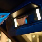 W nowoczesnym wnętrzu samochodu znajduje się eleganckie lustro, które podkreśla zarówno funkcjonalność, jak i styl