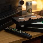 Układanie starych taśm VHS w pobliżu zdalnego sterowania na drewnianym stole