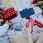 Nieznany dzieciak używający joystick i smartfona