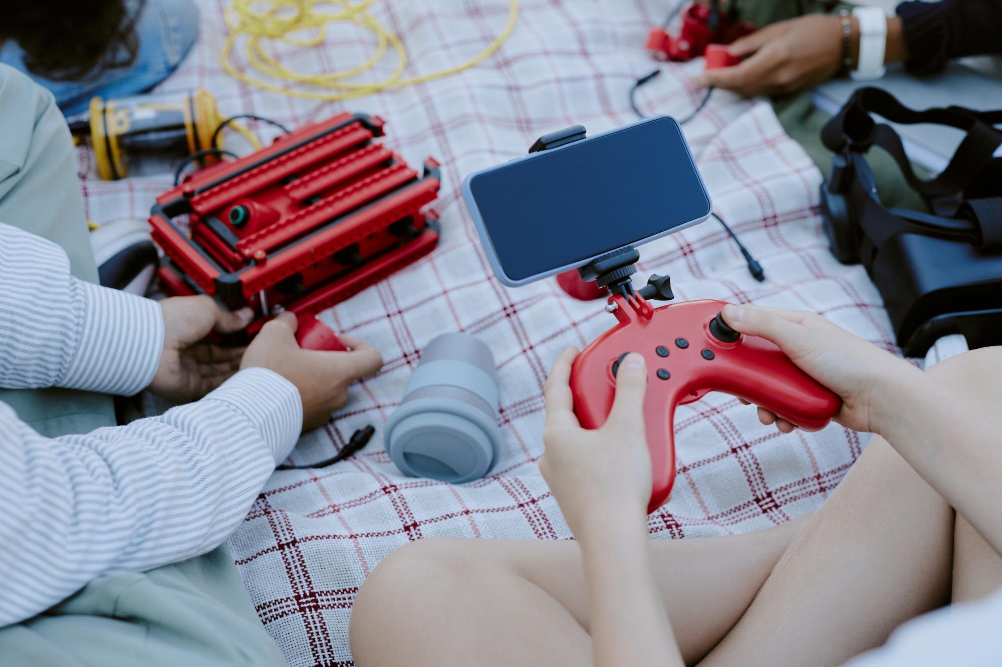 Nieznany dzieciak używający joystick i smartfona