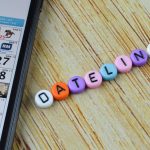 Smartfon z aplikacją kalendarza na ekranie i koralikami alfabetu z tekstem DEADLINE