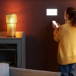 Młoda kobieta korzystająca z cyfrowego systemu inteligentnego domu