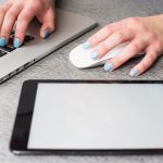 Cyfrowa pastylka blisko bizneswoman ręki używać laptop i myszy na biurku