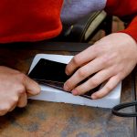 Technik naprawia i zastępuje zepsuty ekran na smartfonie