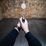 Strzelanie na poligonie strzelniczym broń w rękach człowieka celująca w cel