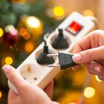 Zbliżenie na ręce kobiety podłączania wtyczki do gniazdka elektrycznego z bliska