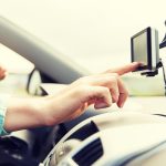 koncepcja transportu, podróży służbowej, technologii, nawigacji i ludzi - zbliżenie męskiej dłoni za pomocą nawigatora gps podczas jazdy samochodem