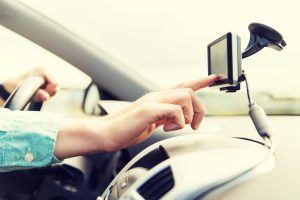 koncepcja transportu, podróży służbowej, technologii, nawigacji i ludzi - zbliżenie męskiej dłoni za pomocą nawigatora gps podczas jazdy samochodem