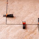 System wyrównywania płytek z plastikowymi zaciskami i klinami strzelanymi podczas ustawiania moździerza do płytek