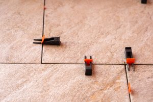 System wyrównywania płytek z plastikowymi zaciskami i klinami strzelanymi podczas ustawiania moździerza do płytek