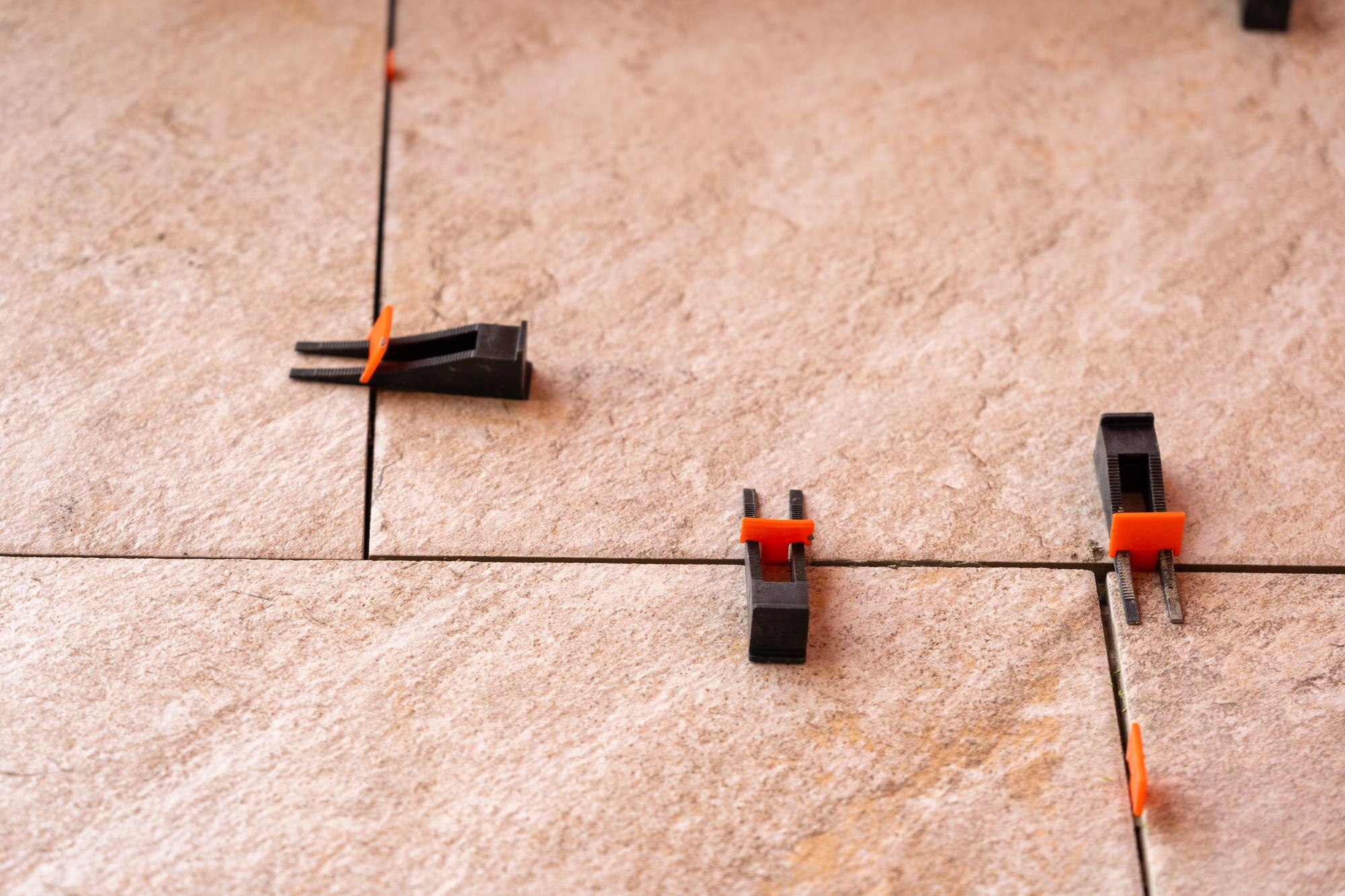 System wyrównywania płytek z plastikowymi zaciskami i klinami strzelanymi podczas ustawiania moździerza do płytek