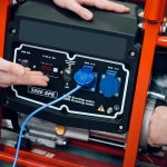 Sprzedawca pokazuje klientom nowy generator w sklepie z narzędziami elektrycznymi