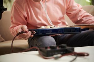 Muzyk podłączający przewód do gitary elektrycznej