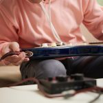 Muzyk podłączający przewód do gitary elektrycznej