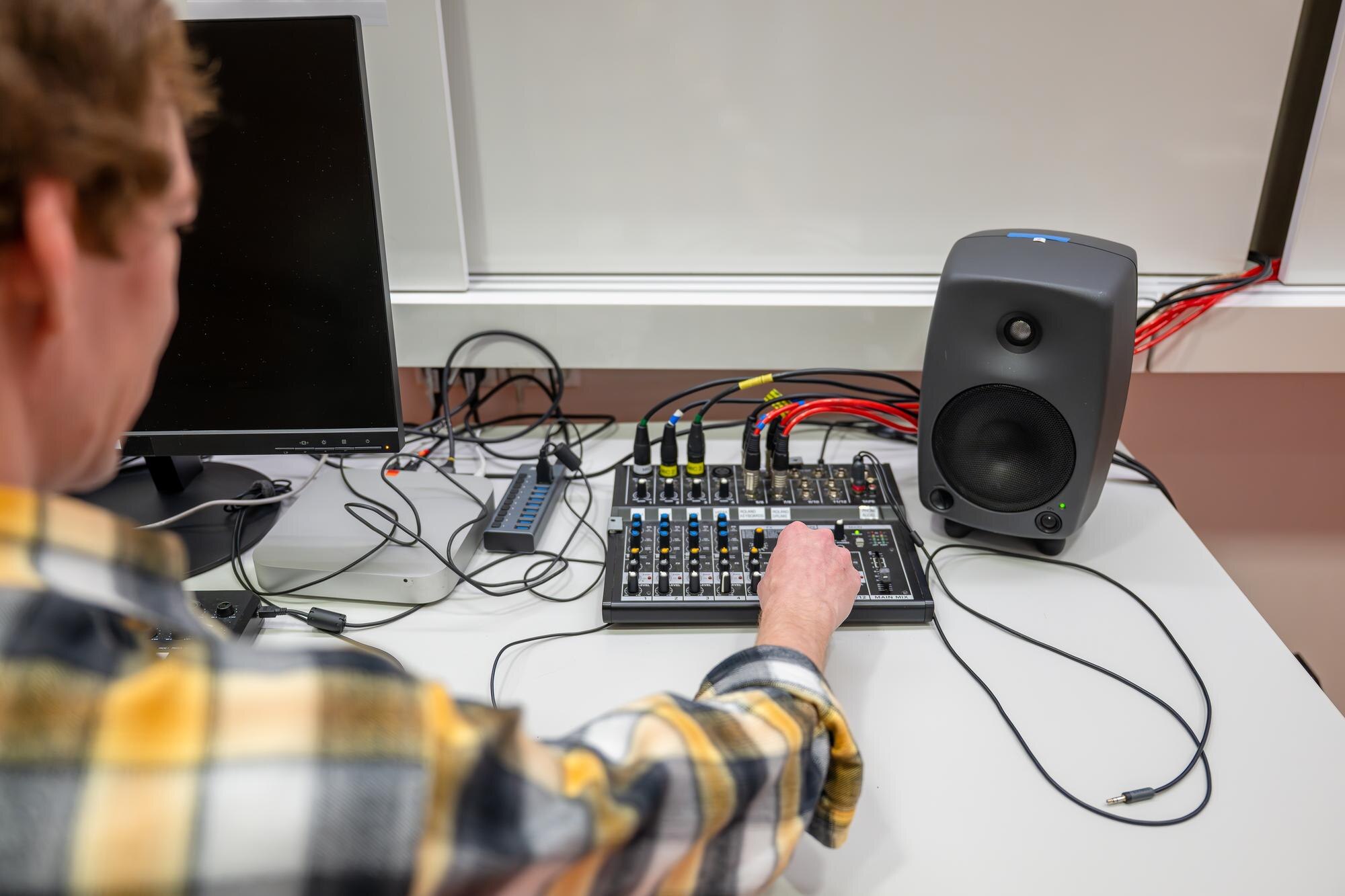 Inżynier dźwięku pracuje nad konsolą do miksowania dźwięku z podłączonymi kablami