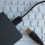 Zewnętrzny dysk twardy podłączony do białego laptopa