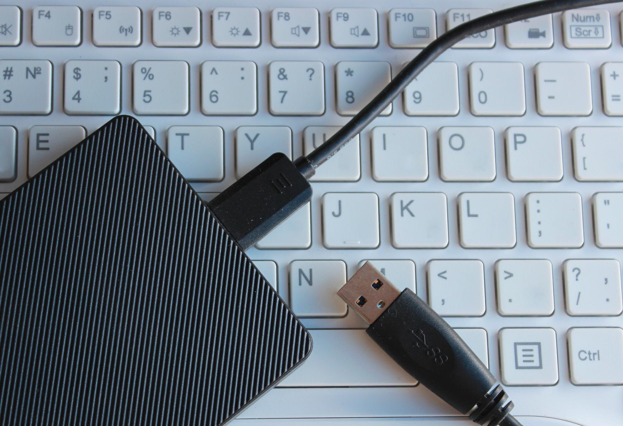 Zewnętrzny dysk twardy podłączony do białego laptopa