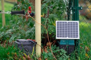 Mały widok farmy słonecznej z małym panelem słonecznym podłączonym do ogrodzenia na farmie