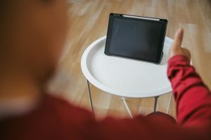 Starszy mężczyzna odbywający rozmowę wideo w domu z lekarzem terapeutą za pomocą tabletu