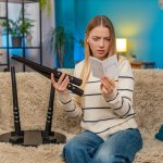 Biała kobieta próbująca zrozumieć instrukcje montażu stołu zdezorientowana i sfrustrowana w domu