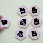 Formaty plików i koncepcja folderów przedstawione za pomocą drewnianych żetonów na pastelowym tle