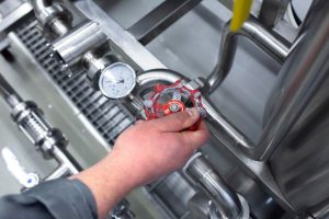 Złota rączka obraca zawór rurki w fabryce