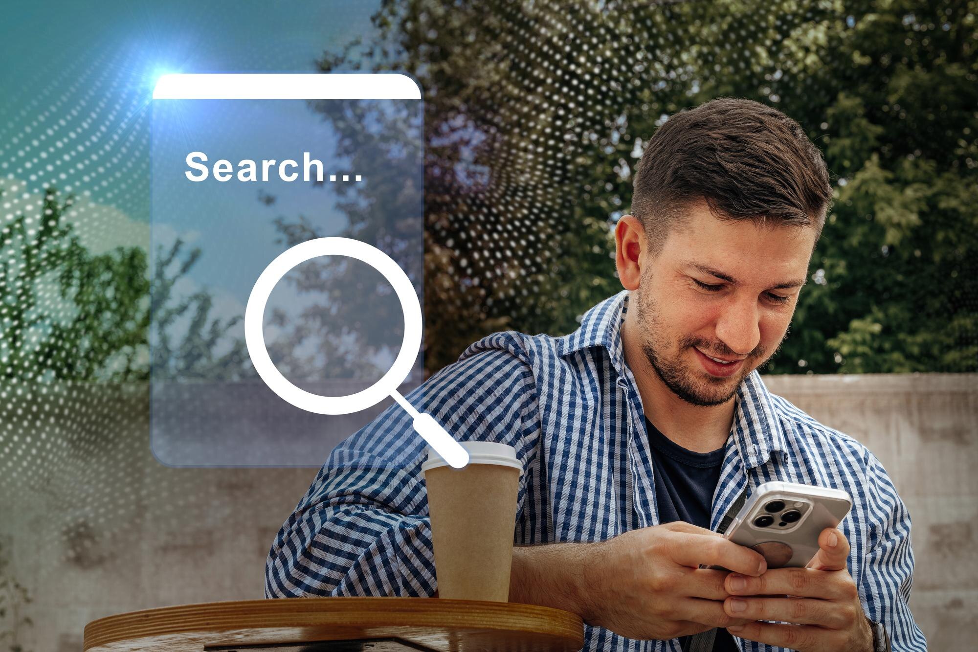 Man using smartphone to search online while enjoying coffee outdoors in urban setting during daytime