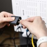 Person connecting an Ethernet cable into a network adapter symbolizing crucial internet connectivity setup IT infrastructure and maintenance tasks