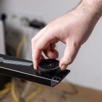 Worker39s hand carefully installs a durable black adjustable plastic foot onto a sturdy new metal furniture leg demonstrating practical home assembly maintenance and DIY repair skills