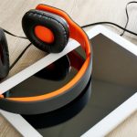 Słuchawki z tabletem i notebookem na drewnianym stole