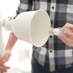 Mężczyzna zmienia żarówkę w lampie w domu