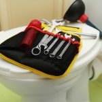 Narzędzia hydrauliczne na pokrywce siedzenia toalety w pomieszczeniach